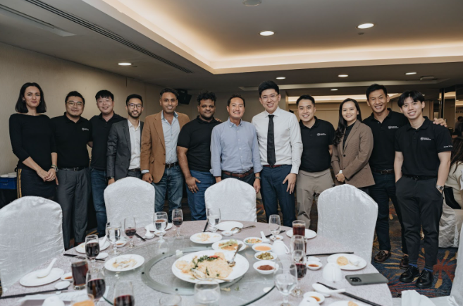 A group of people smiling and posing for a photo at a beautifully set dinner table.
