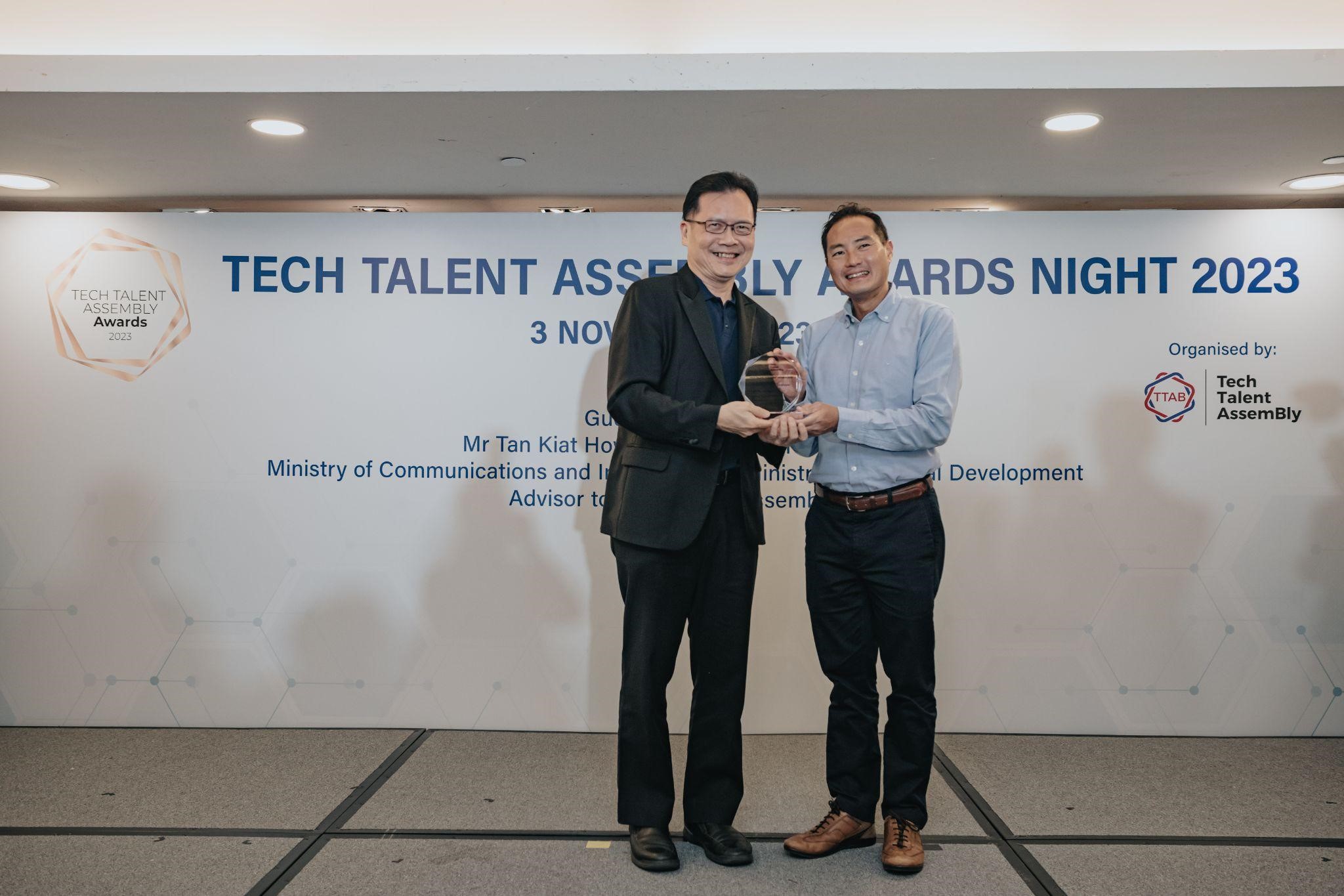 Two men in suits proudly holding an award, symbolizing their achievement and success.